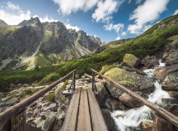 Hory krajina s mostem dřeva a vodní kaskády — Stock fotografie