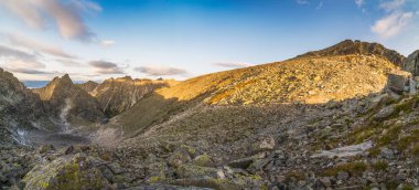 Gün doğumunda bir Yazlık ile Dağlar