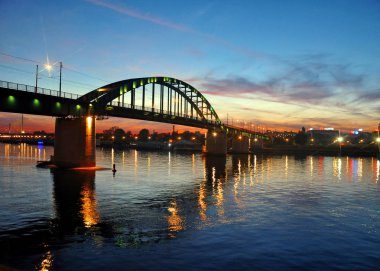 Sava 'da gün batımı, şehrin eski bölümünü Yeni Belgrad' a bağlayan Eski Sava Köprüsü 'ne bakıyor.. 