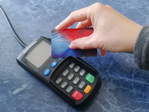 网上购物，非接触式支付。女店员在付款终端上持有信用卡. — 图库照片