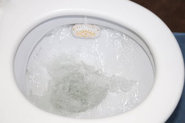 Saf beyaz seramik klozet, sifon çekme işlemi, seçici odaklanma. Temizlik ve hijyen kavramı