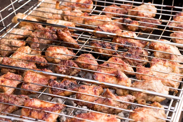 fresh juicy cuts of meat on a barbecue grill, selective focus. the concept of cooking healthy food on fire. closeup of some meat skewers being grilled in a barbecue.