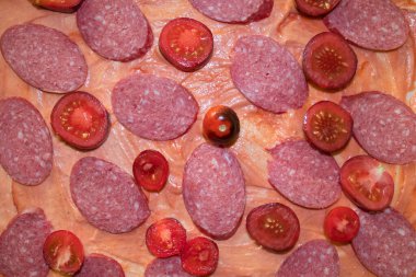 Adım adım talimatlar, dilimlenmiş kiraz domatesleri ve soslu pizza hamurunda dilimler. Adım adım, ev yapımı pizza yapma talimatı. Dördüncü adım. Yukarıdan görüntüle.