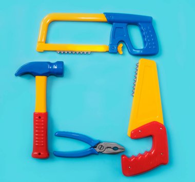 Çocuk için oyuncak aletler. Pils, testere, çekiç mavi arka planda. Babalar Günü, inşaat endüstrisi, inşaat ve onarım konsepti. Metin için yer