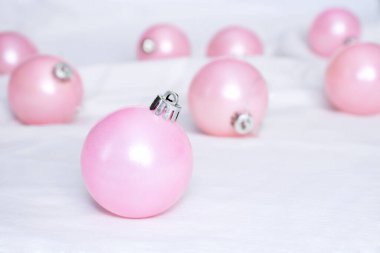 Pembe Noel ağacı topları beyaz kumaşa takılır. Noel asgari konsepti. seçici odak.