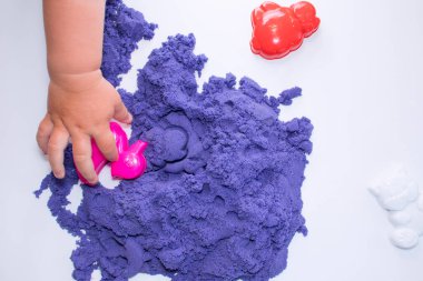 Çocuk elleri kinetik kumla bir oyun oynar. Çocukların motor becerilerinin gelişimi, anaokulu eğitimi. Mesajlaşmak için bir yer. Boşluğu kopyala,