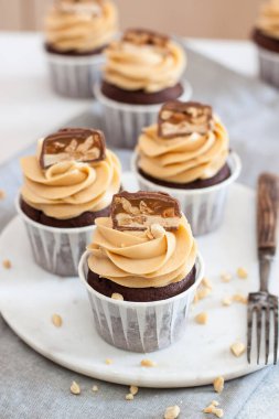 Fıstık ezmeli, çikolatalı kek ve gri keten masa örtüsünün üzerinde fındık. Çikolata hamuru ve badem ezmesi..