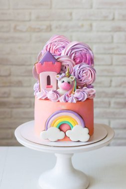 Tatlı pembe doğum günü pastası, sevimli tek boynuzlu at, zencefilli prenses şatosu, gökkuşağı ve kremalı bulutlu küçük bir kız için..