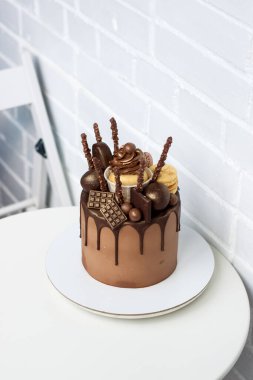 Zarif çikolatalı pasta, erimiş siyah çikolata, kek, kekler, kurabiyeler, beyaz arka planda şekerler..