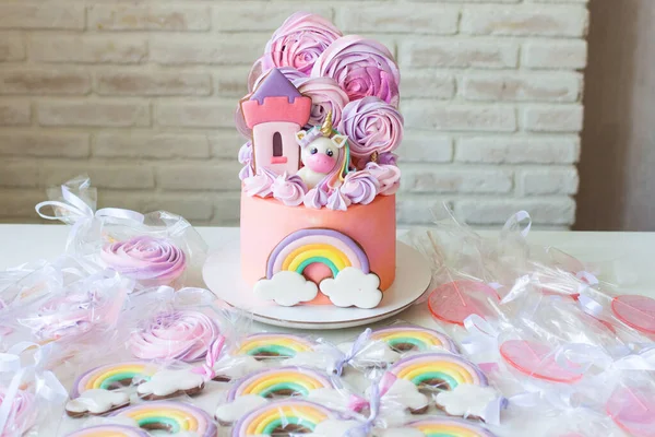 분홍빛 생일 케이크에 유니콘, 무지개, 머랭 구름이 들어 있어. 케이크, 쿠키, 롤리팝을 곁들인 캔디바. — 스톡 사진