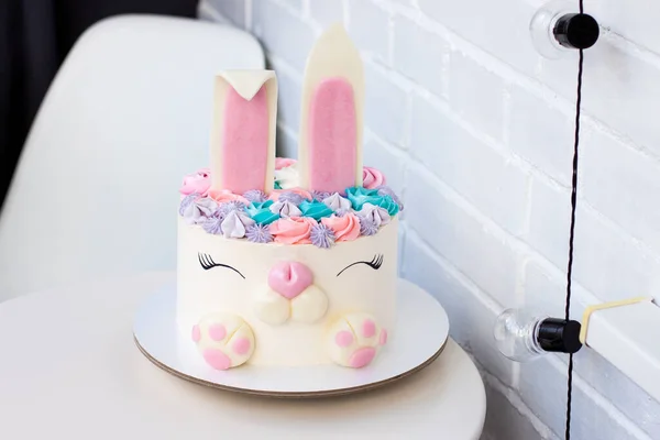Çocukların doğum günü için şirin tavşanlı beyaz ve pembe pasta. Şekerleme ve kremadan yapılmış bir tavşan. Beyaz arkaplan.