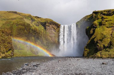 Skogafoss şelalesi. İzlanda doğal turistik. Gökkuşağı ile Sonbahar manzara.