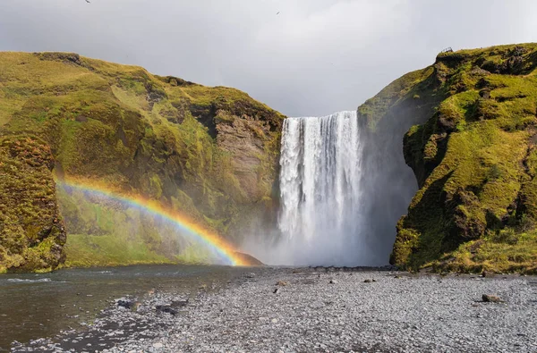 Skogafoss şelalesi. İzlanda doğal turistik. Gökkuşağı ile Sonbahar manzara.