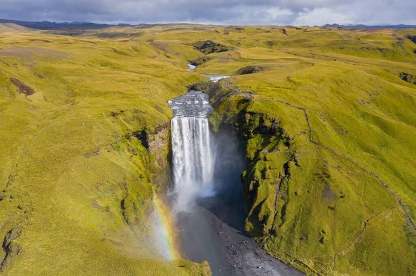 Iceland waterfall Skogafoss in Icelandic nature landscape. Famous tourist attractions and landmarks destination in Icelandic nature landscape on South Iceland. Aerial drone view of top waterfall.