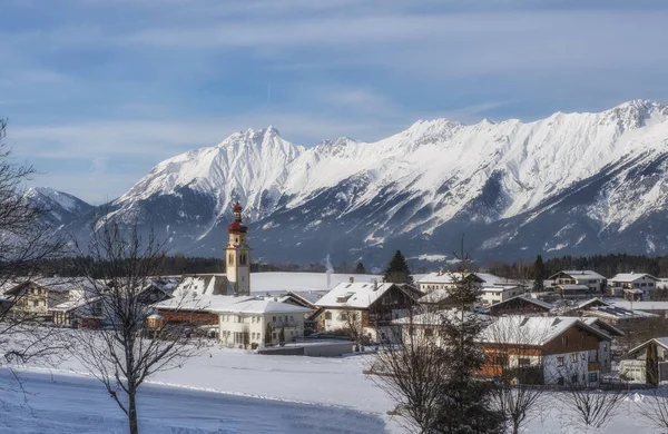 Pueblo austríaco Tulfes cerca de Innsbruck y Heiliger Apostel Thomas iglesia en el día de invierno . — Foto de Stock