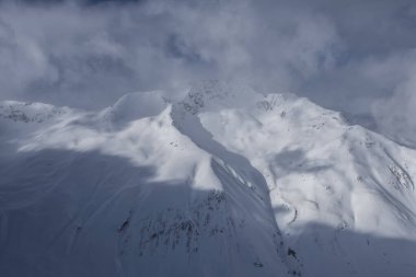 Alp Kayak Tesisi 'nde güneş, bulutlar ve sis ve İtalya' nın Livigno, İtalya 'da kışın kayak yamaçlarında