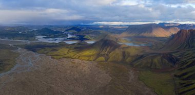 Eylül 2019 'da İzlanda' da. Büyük Vadi Parkı Landmannalaugar. Etrafı rhyolite dağları ve erimemiş karlarla çevrili. Vadide büyük bir kamp inşa edildi. Dünya turları konsepti.