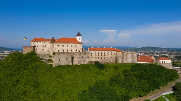 Palanok kale Mukachevo, TransKarpatya bölge Ukrayna mavi gökyüzünün altında kırmızı çatılar ile pitoresk görünümüne. Açık havada çekim yatay.