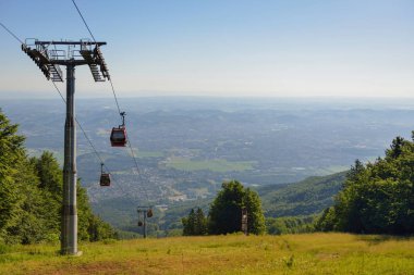 Overhead cable cars at lower station of cableway on Pohorje in Maribor, Slovenia, Mariborsko Pohorje ski slopes are popular hiking destination in summer clipart