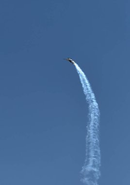 Mavi gökyüzünde akrobasi takım buhar yolları tek bir spor uçak. Düzlem beyaz buhar izleri arka plan izler. Uçak akrobasi manevrası. Budapeşte, Macaristan.