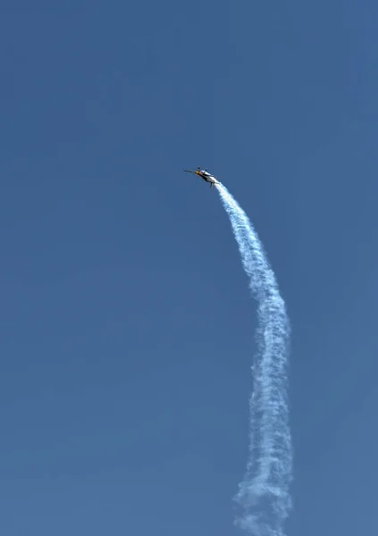 Single one sport plane of aerobatic team vapour trails in blue sky. Plane white vapour trails tracks background. Plane aerobatic maneuver stunt. Budapest, Hungary. — Stock Photo, Image