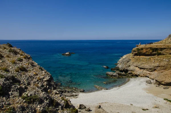 Playa aislada con agua azul clara y pequeños guijarros y arena, lejos del turismo de masas en el pueblo de Chora Sfakion. Creta, Grecia . — Foto de Stock