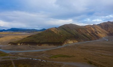 Eylül 2019 'da İzlanda' da. Büyük Vadi Parkı Landmannalaugar. Etrafı rhyolite dağları ve erimemiş karlarla çevrili. Vadide büyük bir kamp inşa edildi. Dünya turları konsepti. Hava aracı görüntüsü.