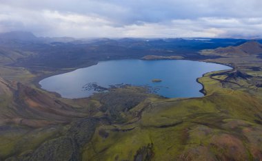Eylül 2019 'da İzlanda' da. Büyük Vadi Parkı Landmannalaugar. Etrafı rhyolite dağları ve erimemiş karlarla çevrili. Vadide büyük bir kamp inşa edildi. Dünya turları konsepti. Hava aracı görüntüsü.