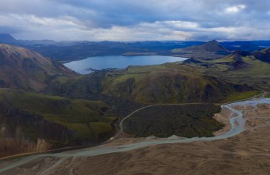 Eylül 2019 'da İzlanda' da. Büyük Vadi Parkı Landmannalaugar. Etrafı rhyolite dağları ve erimemiş karlarla çevrili. Vadide büyük bir kamp inşa edildi. Dünya turları konsepti. Hava aracı görüntüsü.