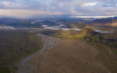 Eylül 2019 'da İzlanda' da. Büyük Vadi Parkı Landmannalaugar. Etrafı rhyolite dağları ve erimemiş karlarla çevrili. Vadide büyük bir kamp inşa edildi. Dünya turları konsepti. Hava aracı görüntüsü.