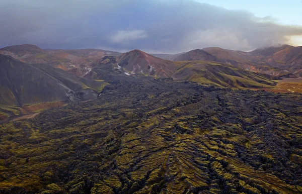 Island v září2019. Great Valley Park Landmannalaugar, obklopen horami rhyolitu a neroztaveného sněhu. V údolí postavili velký tábor. Koncept světových zájezdů. Výstřel ze vzdušného letounu. — Stock fotografie