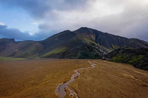 Ισλανδία τον Σεπτέμβριο του 2019. Great Valley Park Landmannalaugar, που περιβάλλεται από βουνά από ριολίτη και λιωμένο χιόνι. Στην κοιλάδα χτίστηκε μεγάλο στρατόπεδο. Η έννοια της παγκόσμιας περιοδείας. Αεροπλάνο μη επανδρωμένου. — Φωτογραφία Αρχείου