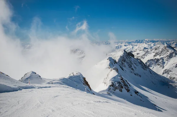 Paesaggio alpino primaverile dal ghiacciaio del Molltal. Rocce, nuvole e sole sulle piste da sci. Austria, Carinzia, aprile 2016 — Foto Stock