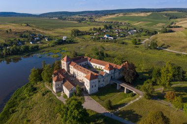 Göl kıyısındaki ortaçağ şatosunun manzarası. Mekan Svirzh, Ukrayna. Uçan kuadkopterden görüntüle .