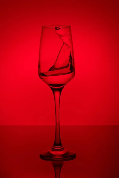 colorful splashes in wineglass on colorful background with colorful water drops