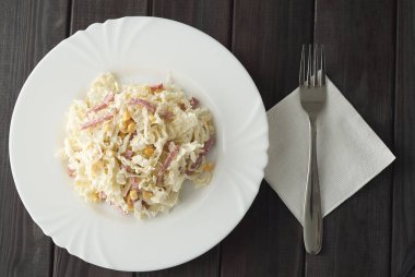 pirzola ve çatal ahşap koyu arka plan üzerinde beyaz bir tabak salata