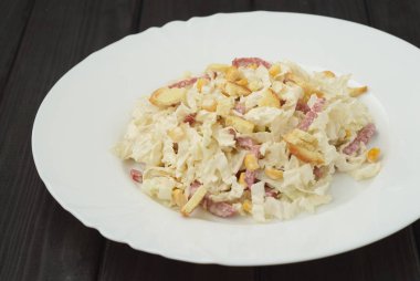 pirzola ve çatal ahşap koyu arka plan üzerinde beyaz bir tabak salata