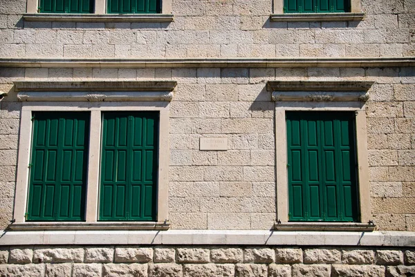Lekka kamienna ściana domu z oknami zamykanymi — Zdjęcie stockowe
