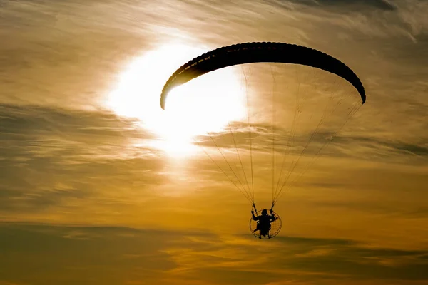 The silhouette of motoparaplane on the background of sunset — Stock Photo, Image