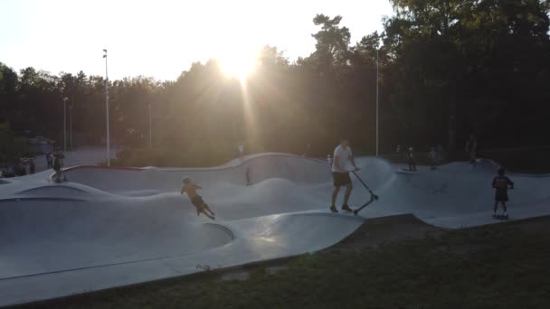 Kids playing in a kick scooter park at sunset — Stock Video