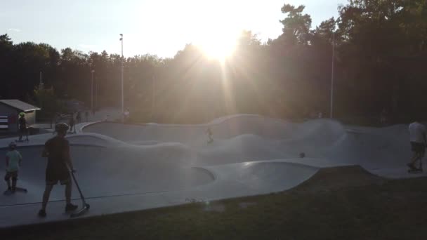 Kids playing in a kick scooter park at sunset — Stock Video