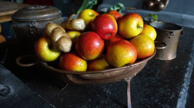 Eski bir metal kasede olgun elmalar ve iki somun ekmek.
