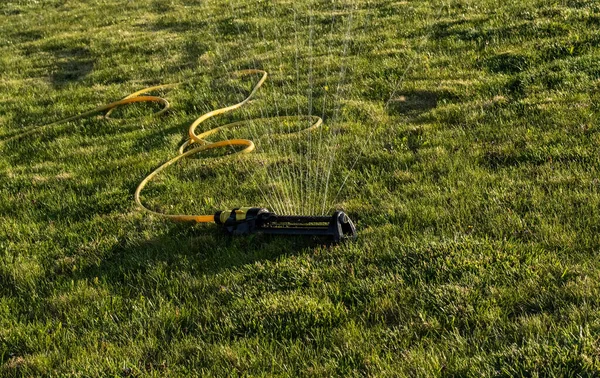 Portable Water Efficient Oscillating Sprinkler Metal Arm Sprays Out Fan — Stock Photo, Image