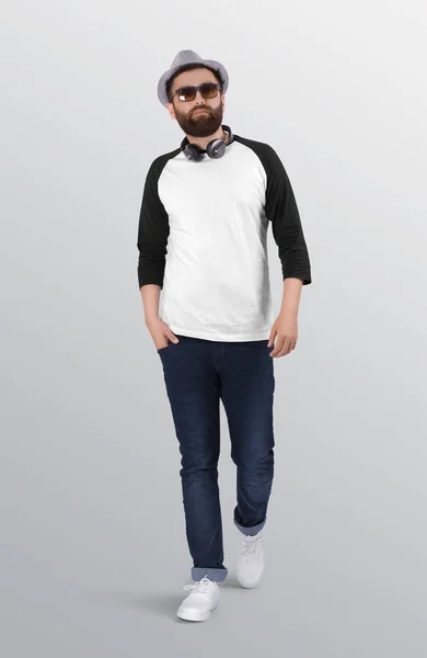 白と黒の無地の3分の2の袖のラグランシャツにブルーのデニムジーンズのパンツを着て髭を生やして歩く 隔離された背景 — ストック写真