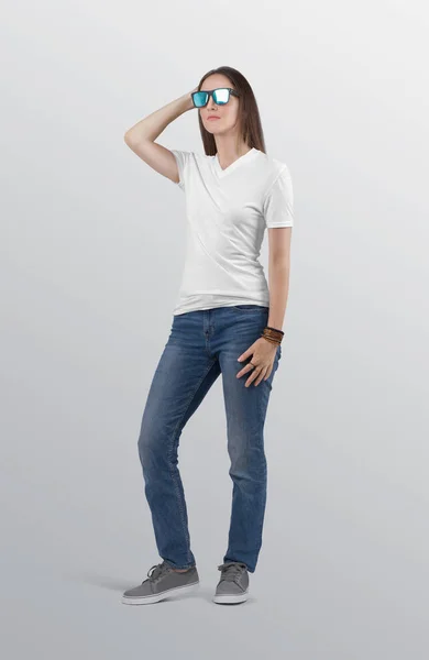 ブルーデニムジーンズパンツを着た白い無地VネックTシャツに美しい女性モデルを立っている 隔離された背景 — ストック写真