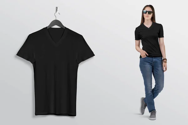 Hanging black plain v neck t shirt on wall, with beautiful female model in blue denim jeans pant. Isolated background.