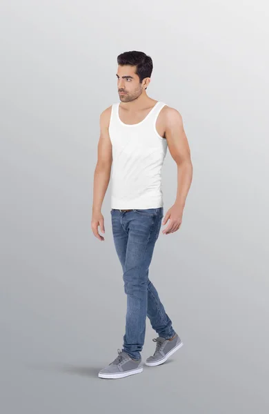 白い無地のタンクトップシャツとデニムブルーのジーンズパンツで男性モデルを歩く隔離された背景に — ストック写真