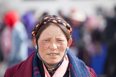 Geleneksel örgü ve mücevher takan Khampa 'lı bir kadın, Lhasa' daki Jokhang tapınağında (bir tür Budist hac yolculuğu) Kora 'da yürüyor..