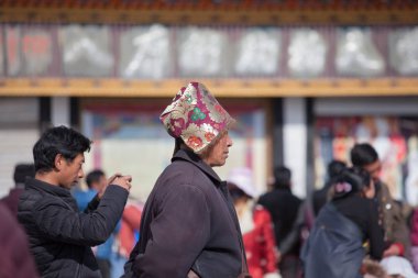 Geleneksel Tibet şapkası takan bir hacı, Barkhor Meydanı 'ndaki Tibet Budizmi' nin en kutsal tapınağı olan Jokhang 'ın etrafındaki Kora' da yürür..