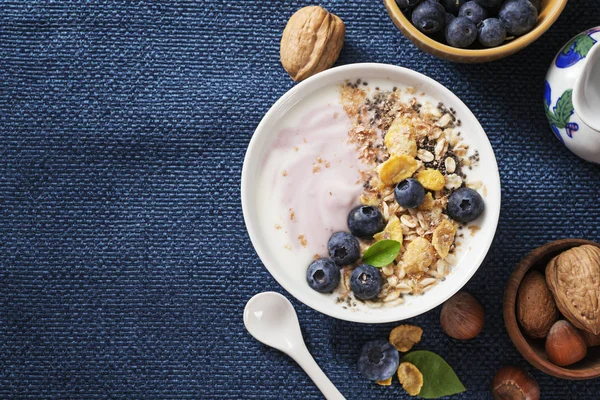 Yoğurt, kahve ve koyu mavi peçete üzerinde çeşitli tahıl taze yaban mersini ile sağlıklı klasik kahvaltı. Metin alanı.